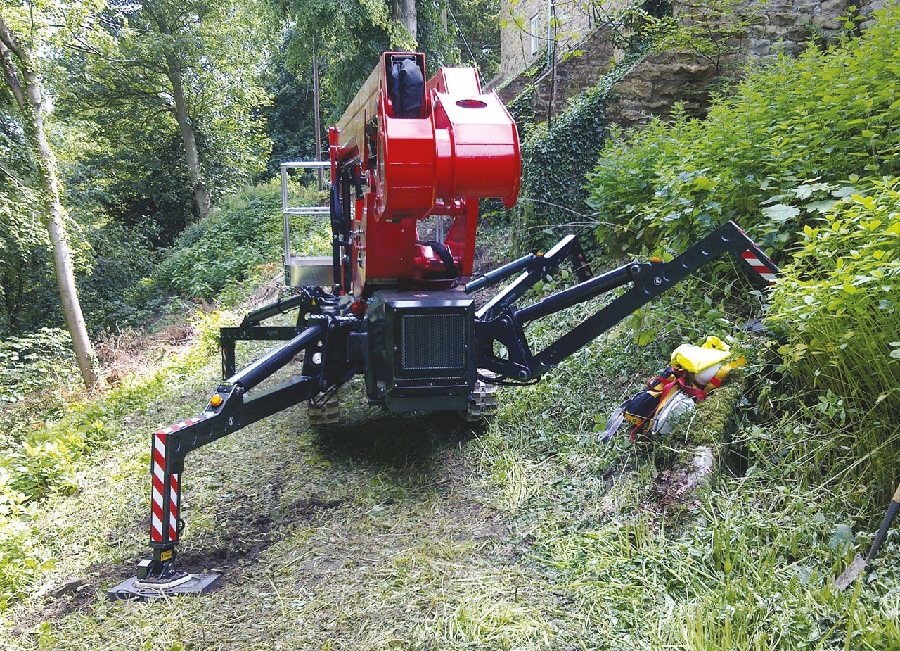Spider lift deployed on uneven terrain with stabilizers extended